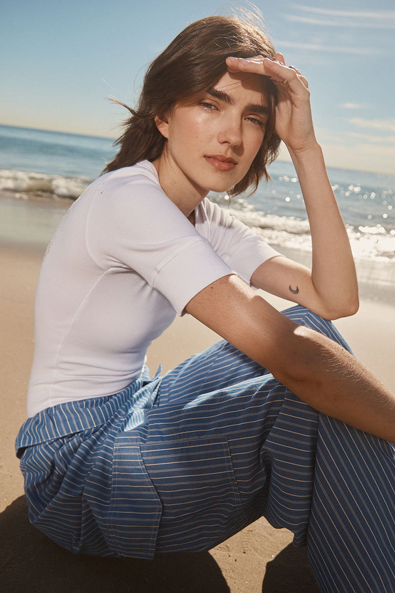 Stateside Luxe 2x1 Rib Scoop Neck Bodysuit in White-model is sitting on the beach 