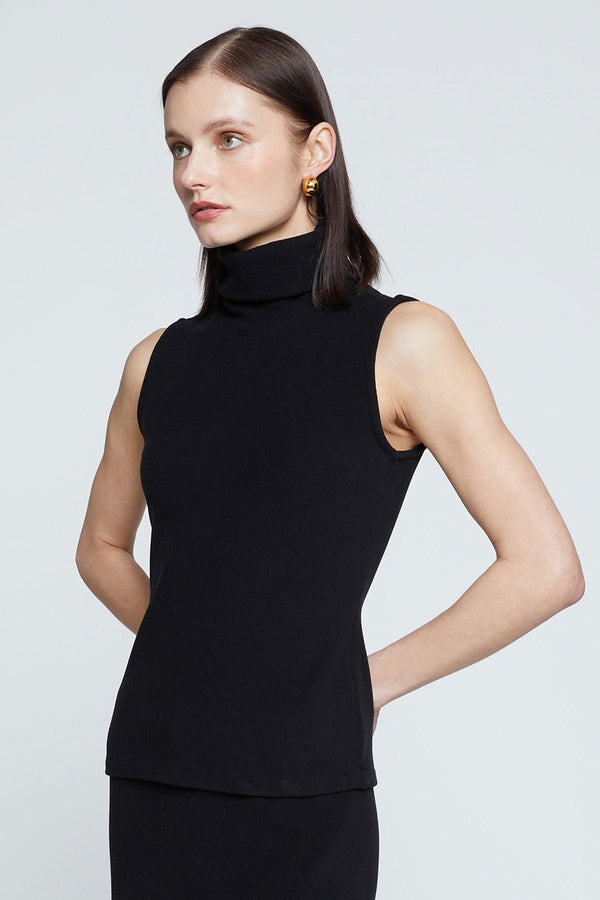 Stateside Honeyluxe Flat Back Rib Sleeveless Turtleneck-side view models hands are behind her back