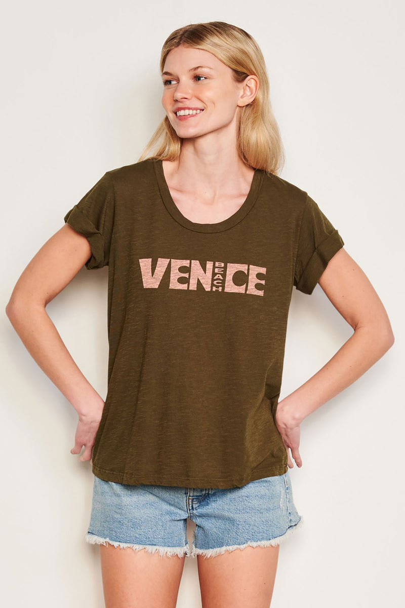 Sundry Venice Rolled Sleeve Tee in Olive-model is looking past her shoulder and has her hands on her hip 